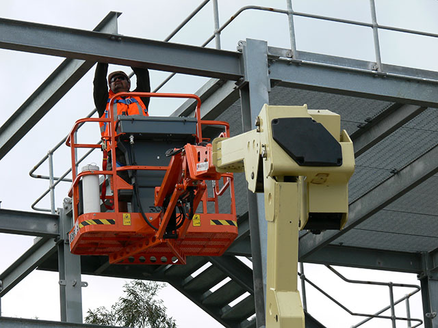 Worker on a elevating work platform with overhead structures that may pose a crush risk