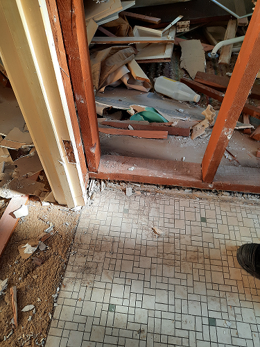 Demolished bathroom showing asbestos particles still present
