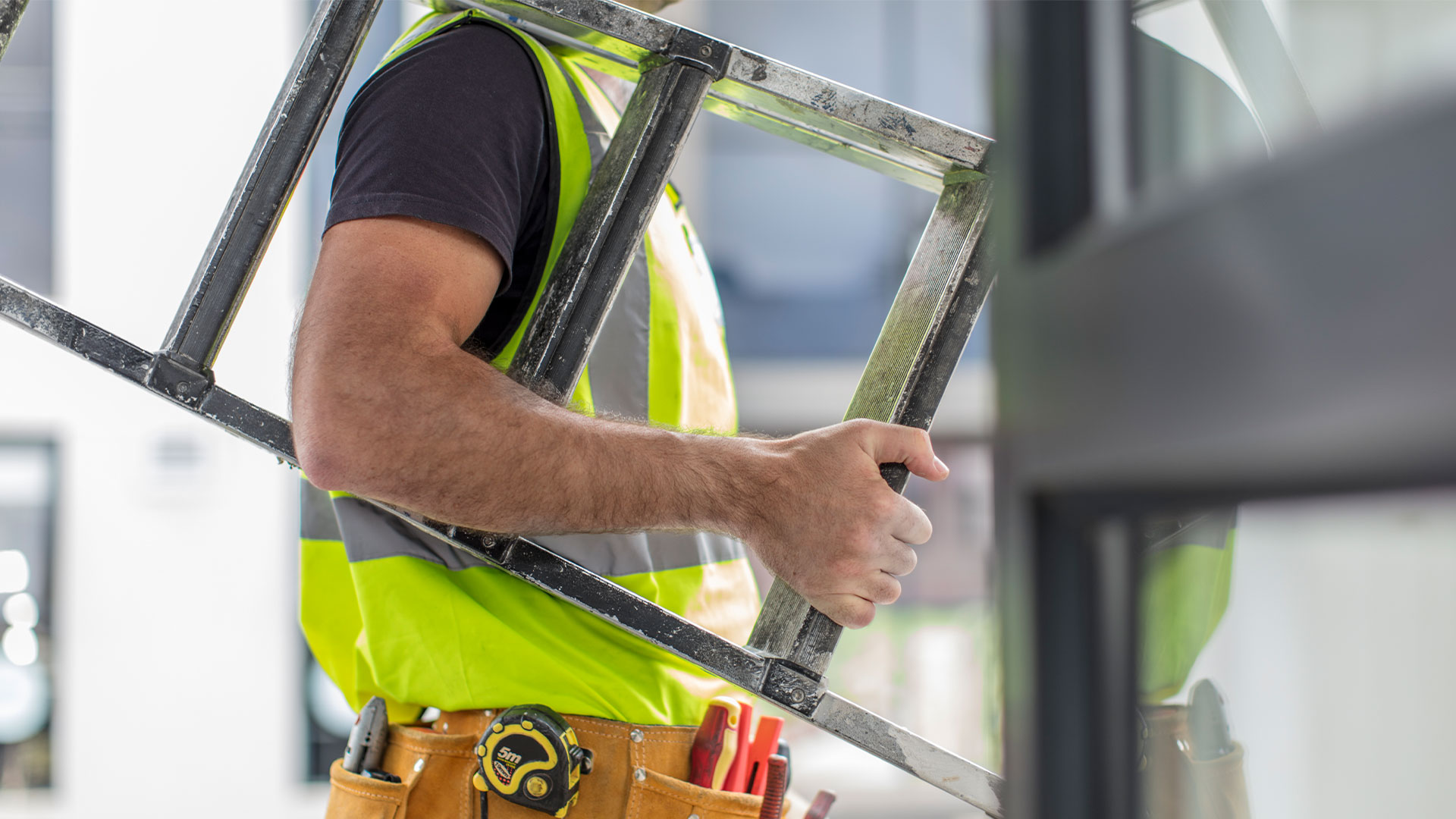 Closeup of construction worker holding a ladder